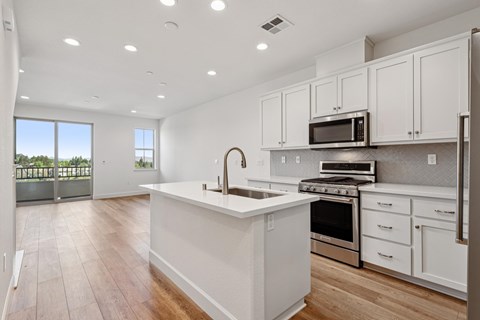 A modern kitchen with white cabinets and stainless steel appliances.