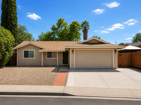 A house with a garage and a driveway in front of it.
