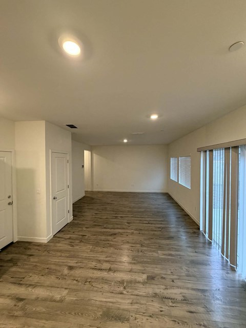 A room with wooden flooring and white walls.