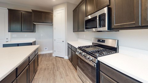 A kitchen with a white counter top and a black stove.
