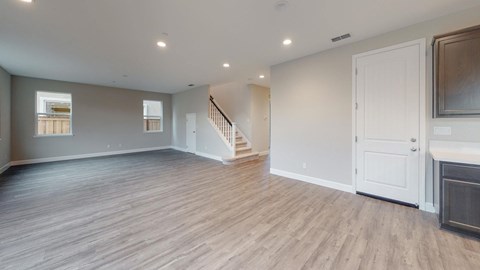 A spacious room with wooden flooring and white walls.