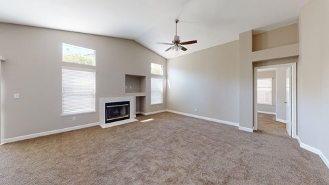 A living room with a fireplace and a ceiling fan.