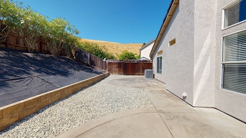 A house with a gravel driveway and a covered patio area.