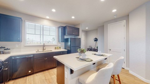 A modern kitchen with a dining table and chairs.