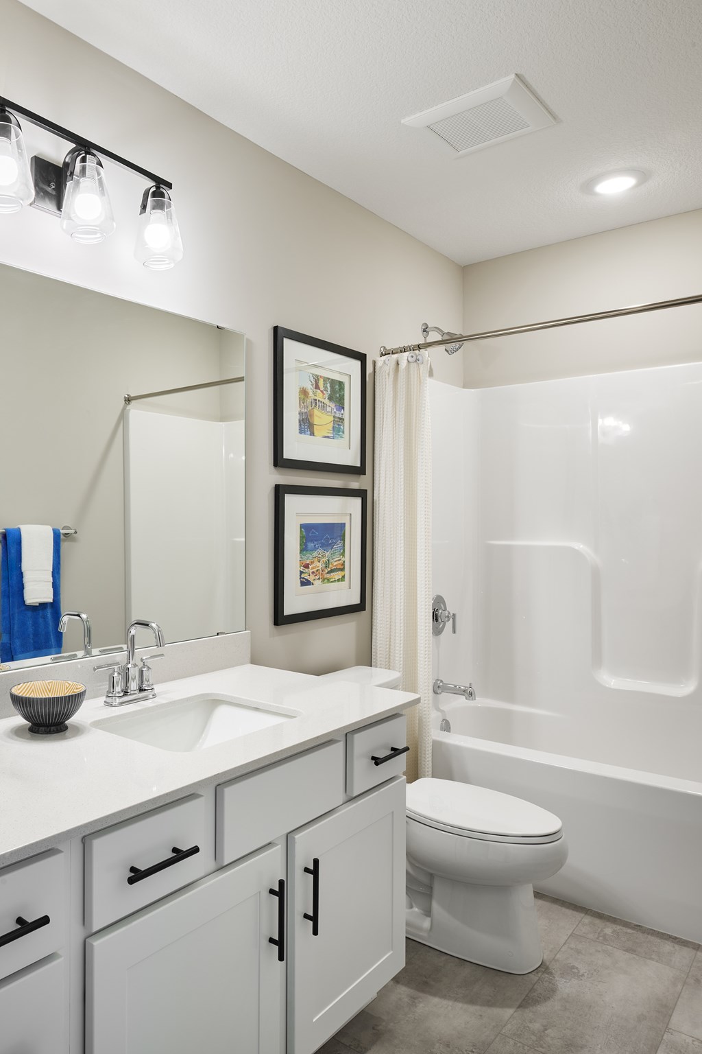 A white bathroom with a toilet, sink, and a shower.