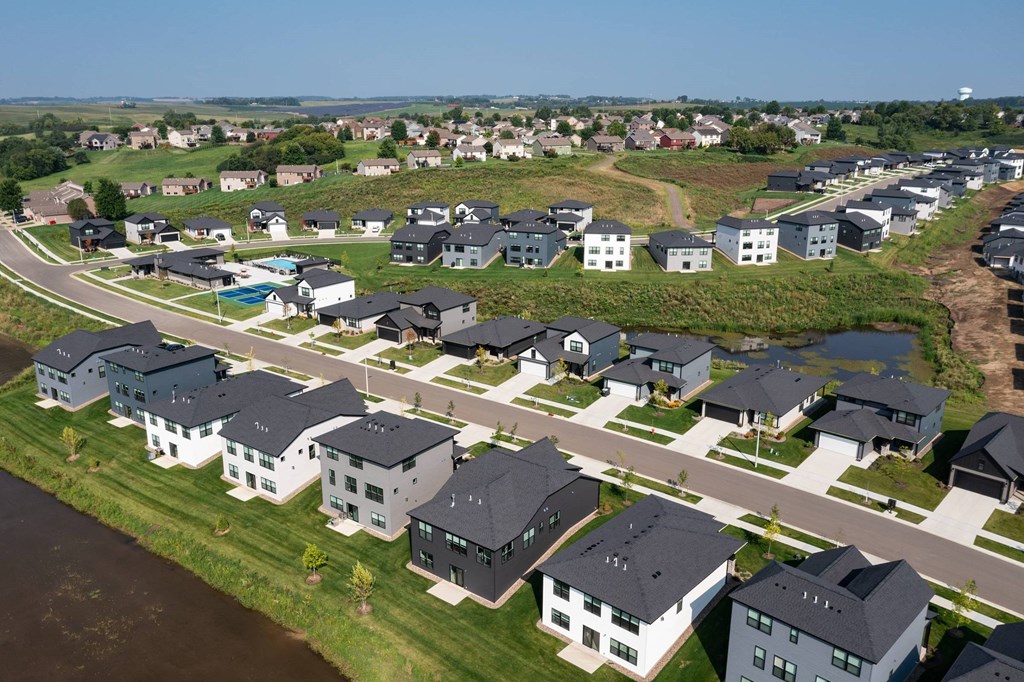 A row of houses with a body of water in front of them.