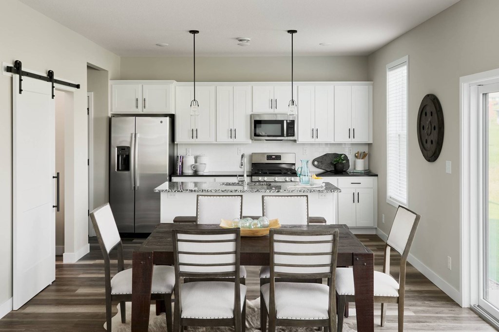 A modern kitchen with a dining table and chairs.