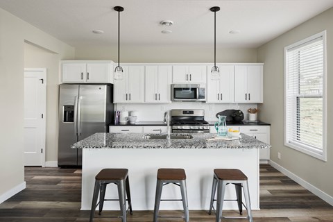 A kitchen with white cabinets and a granite countertop.