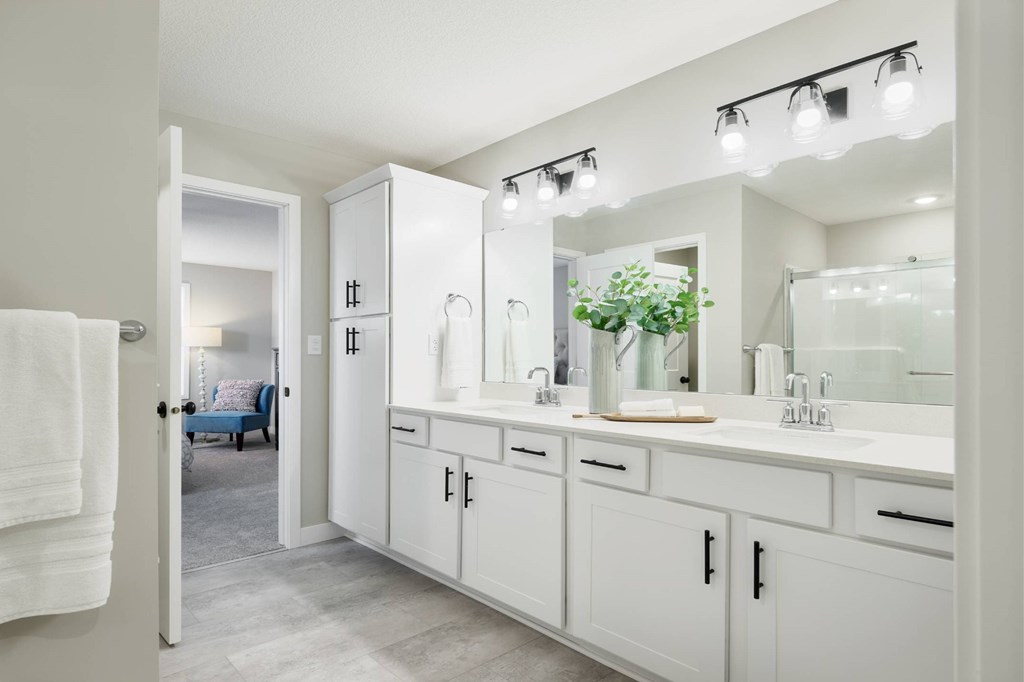 A white bathroom with a mirror and lights above it.