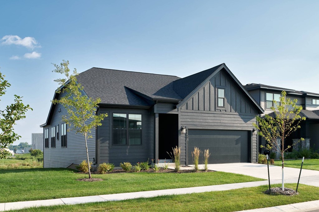 A modern house with a grey exterior and a black garage door.