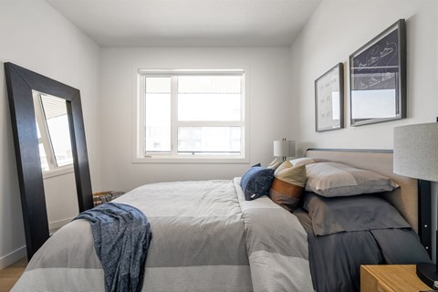 A bedroom with a large bed and a window.