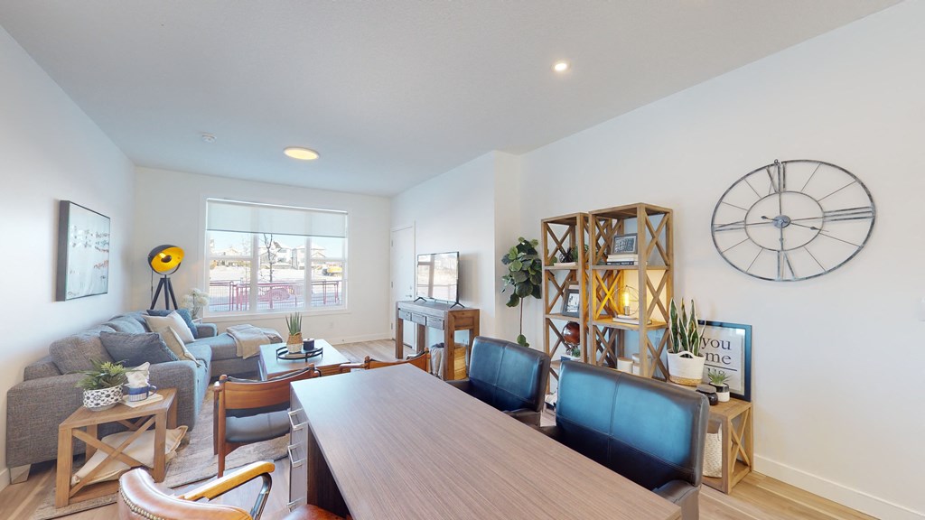 A living room with a long wooden table and blue chairs.