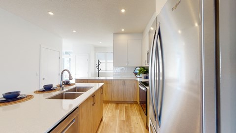 A modern kitchen with a stainless steel refrigerator and wooden cabinets.