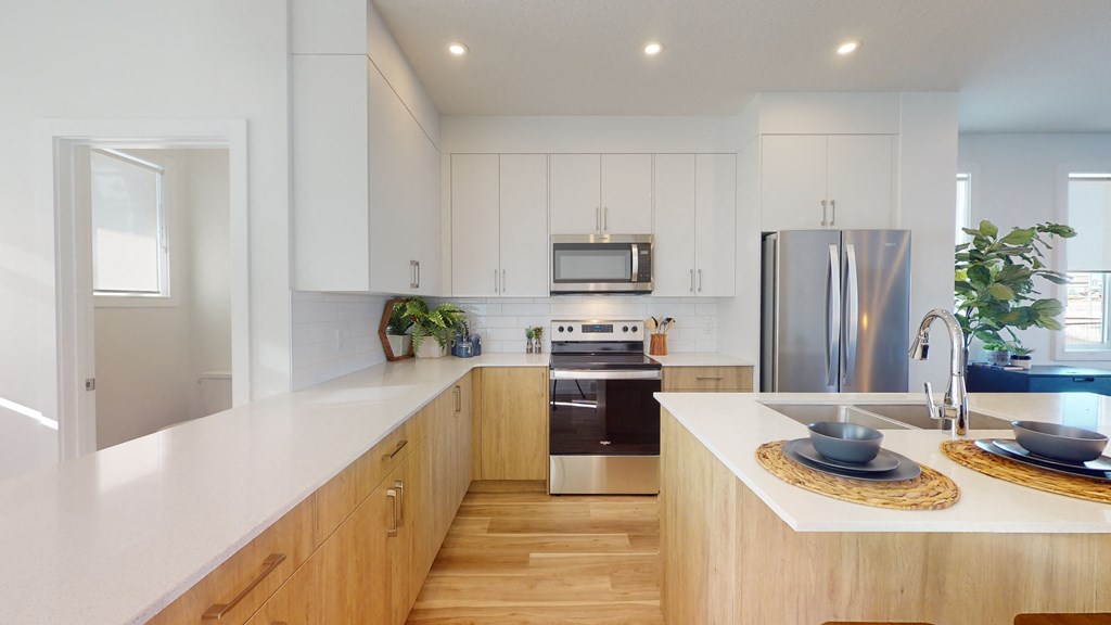 A modern kitchen with wooden cabinets and stainless steel appliances.
