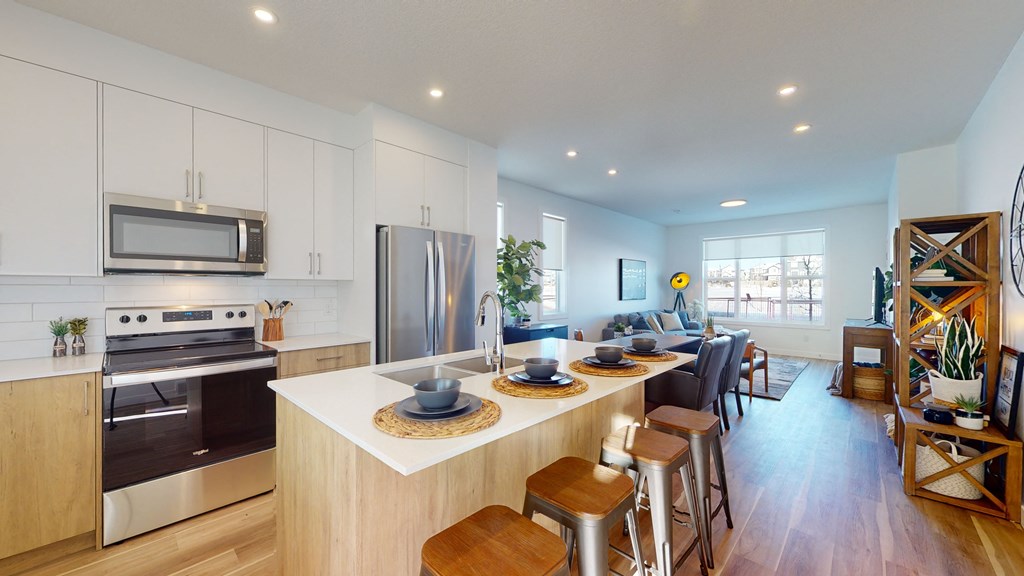 A modern kitchen with stainless steel appliances and wooden cabinets.