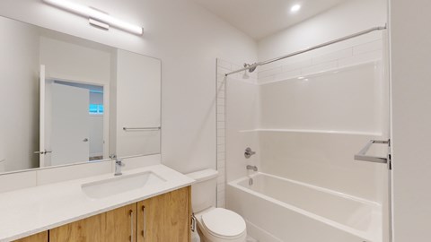 A white bathroom with a toilet, sink, and shower.