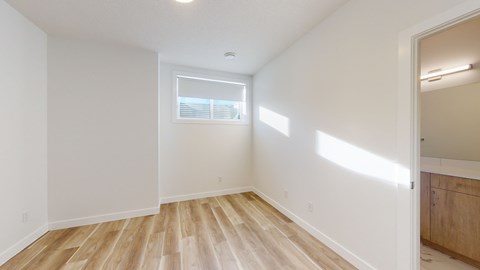 A room with wooden flooring and a window.