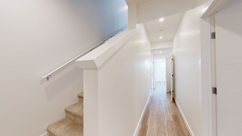 A long hallway with a staircase on the left side.