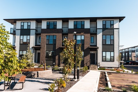 A modern apartment building with a courtyard and benches.
