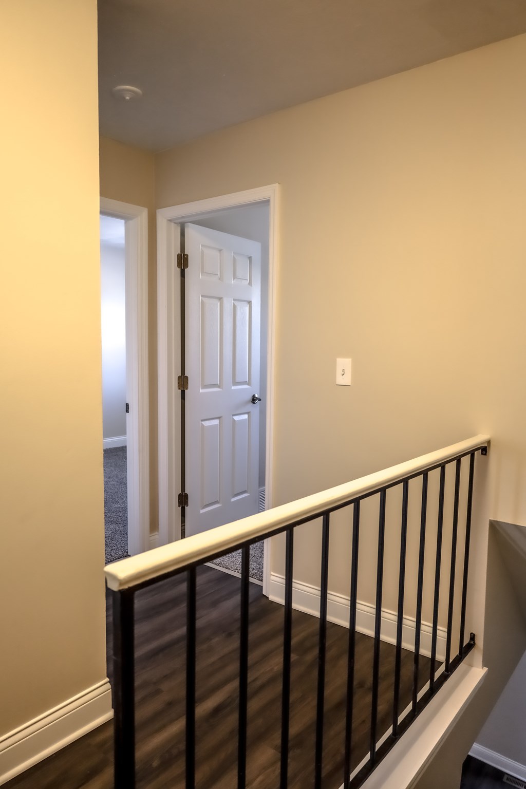 A white door is at the end of a hallway.