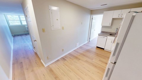 A kitchen area with white cabinets and a refrigerator.