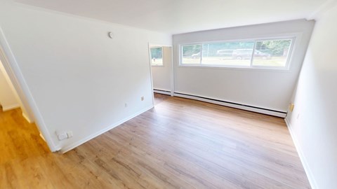 A room with wooden flooring and a window.
