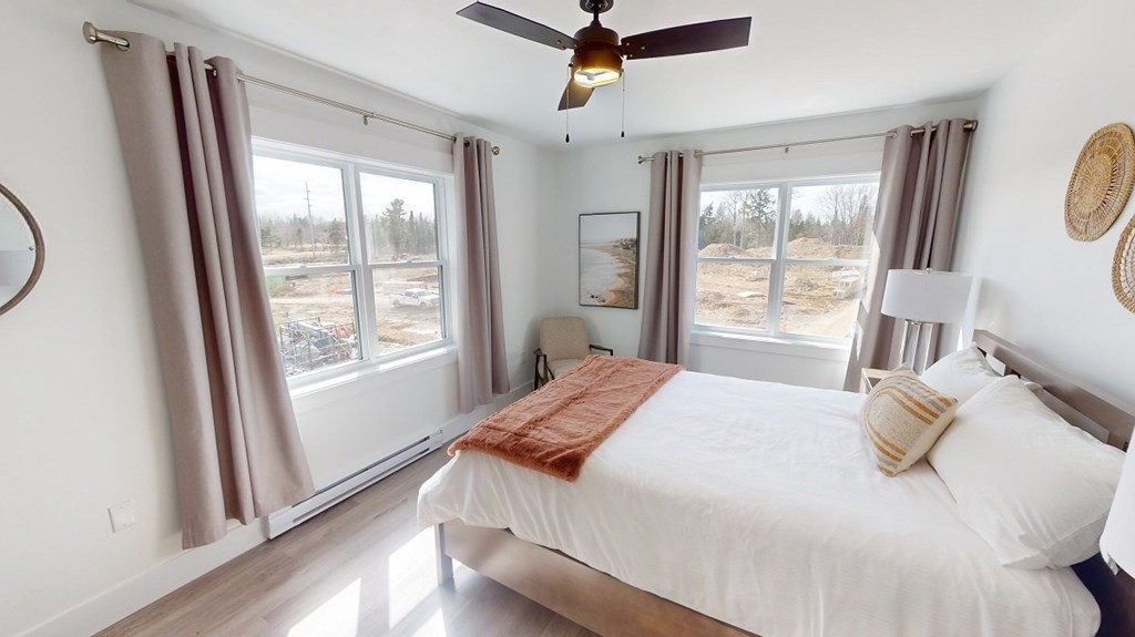 A bedroom with a large bed and a ceiling fan.