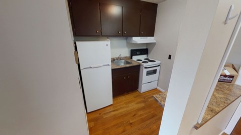 A kitchen with a white refrigerator and a stove top oven.