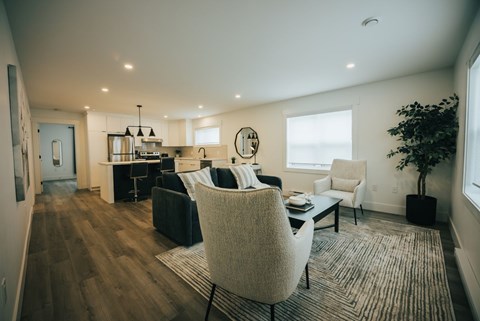 A modern living room with a black couch and a white chair.
