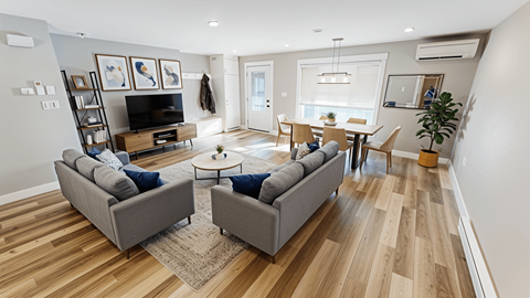 A living room with a grey couch and a wooden floor.