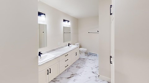 A bathroom with a marble floor and white walls.