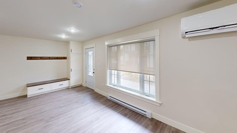 A room with a window and a bench under a window.