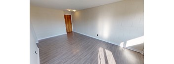 A room with wooden flooring and a door.