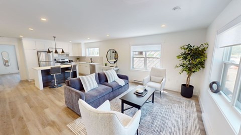 A modern living room with a grey sofa and a white chair.