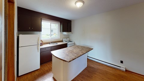 A kitchen with a white refrigerator and wooden cabinets.