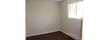 A room with a window and wooden floors.