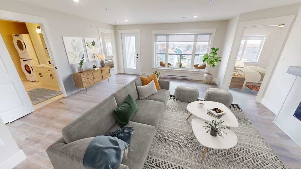 A living room with a grey sofa and a white coffee table.