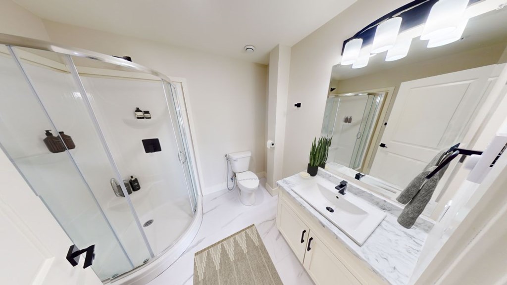 A modern bathroom with a glass shower stall and a sink vanity.