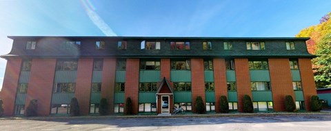 A red and green building with a clear blue sky in the background.