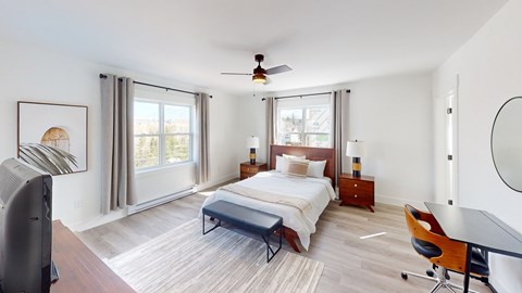 A bedroom with a bed, a chair, and a ceiling fan.