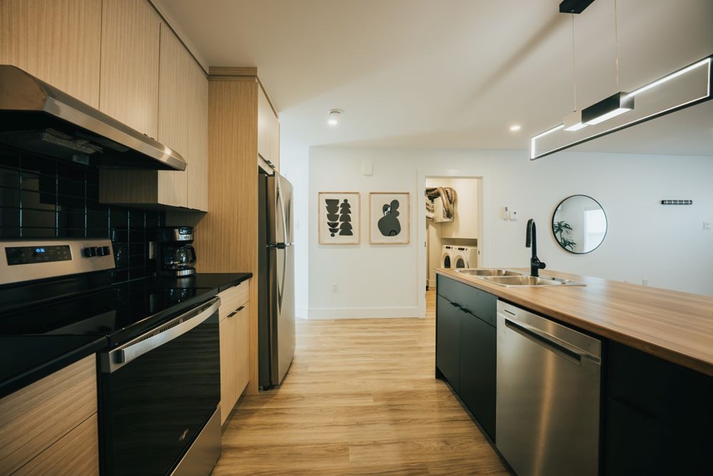 A modern kitchen with wooden cabinets and stainless steel appliances.