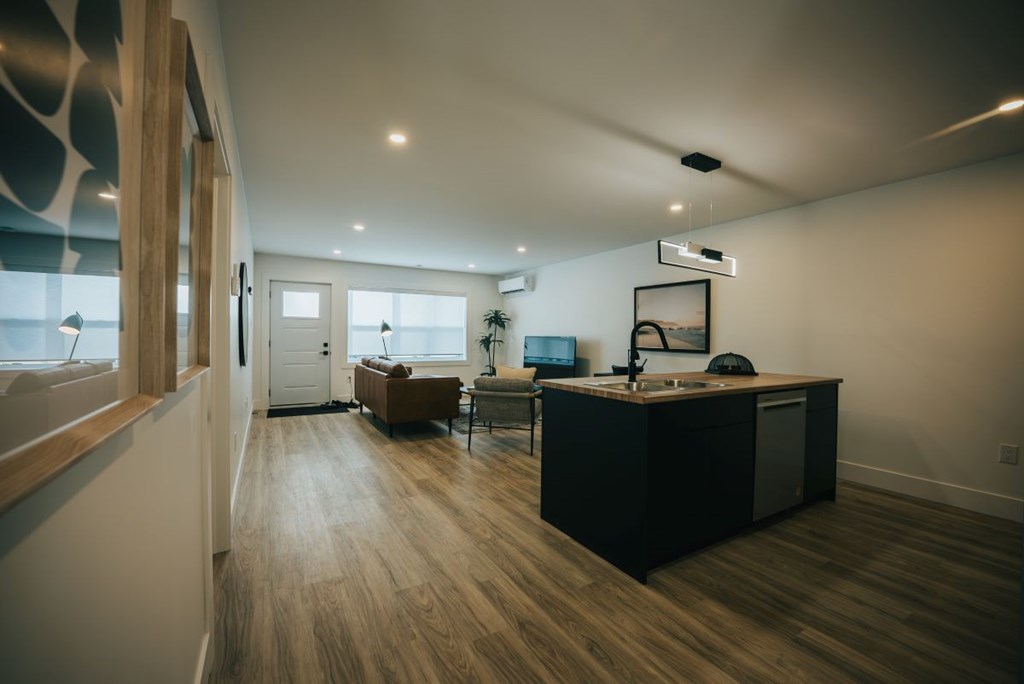 A modern kitchen with a wooden floor and a large island.
