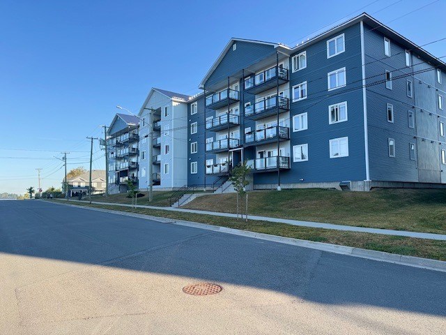 A street view of a residential area with apartment buildings.
