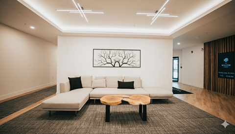 A modern living room with a white couch and a tree-like picture on the wall.