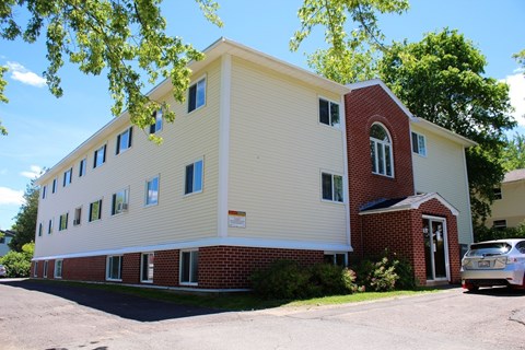 A white and red building with a car parked in front.