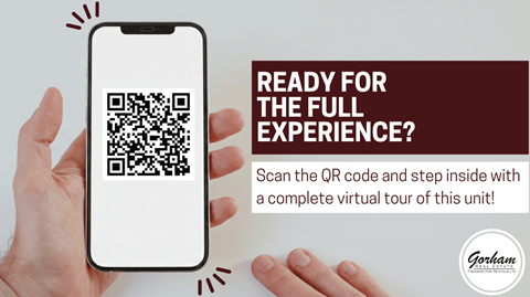 A hand holding a smartphone displaying a QR code with the text