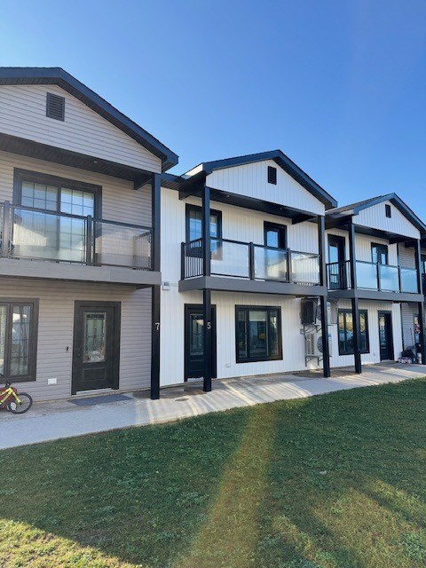 A row of modern houses with balconies and glass doors.