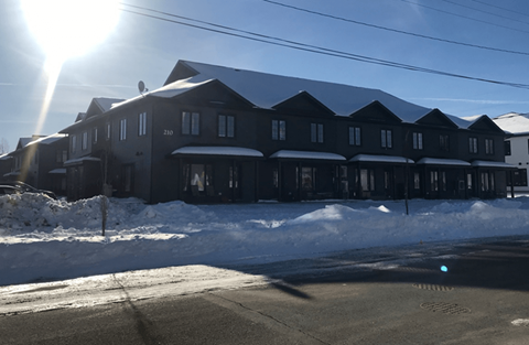 A large black building with the number 2210 on it is surrounded by snow.