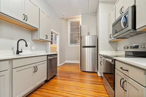 A kitchen with white cabinets and stainless steel appliances.