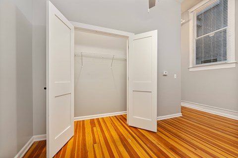 A room with a white door and a wooden floor.